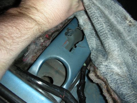 1990 Ford Mustang - A person's hand is visible near a damaged section of a car's interior paneling.