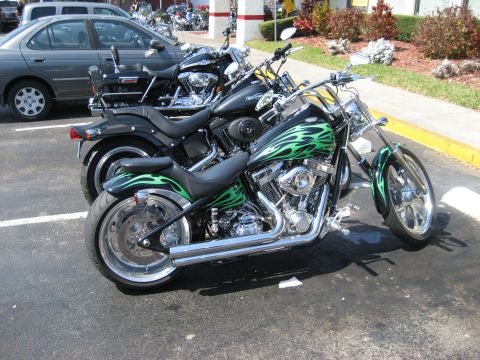 1986 Ford Bronco - Two motorcycles are parked in a lot, one with a distinctive green flame paint job.