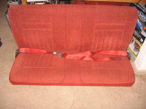 1990 Ford Bronco - A red bench seat with seatbelts is shown, not a 1990 Ford Bronco.