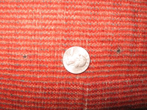 1990 Ford Bronco - A quarter is placed on a red carpet with a striped pattern.
