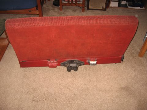1990 Ford Bronco - A red rear seat is shown, likely from an older vehicle, with visible latching hardware.