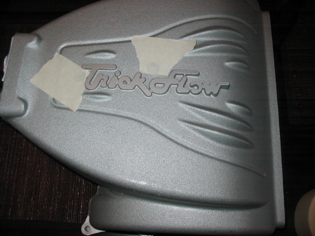 Silver Trick Flow intake manifold with tape covering part of the logo