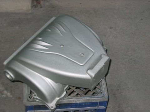 1991 Ford Bronco - A silver painted engine component with a textured surface sits on a blue crate.