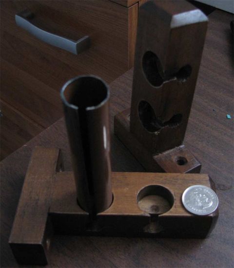 2003 Ford Crown Victoria - Wooden jig with metal tube and coin, likely a custom part or tool. Supermotors.net logo is present.