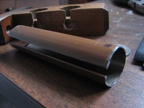2003 Ford Crown Victoria - A close-up view of a brown metal pipe part on a wooden table.