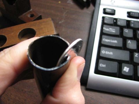2003 Ford Crown Victoria - A coin is placed inside a metal pipe, with a keyboard visible in the background.