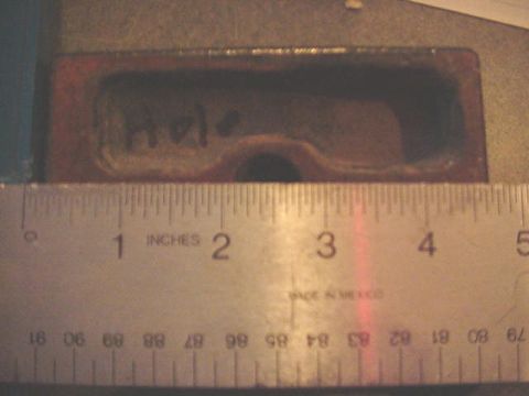 1992 Ford Bronco - Close-up of a rusty rectangular cast-iron recess with "Hole" written on it in marker beside a round hole broken through the bottom of the p…