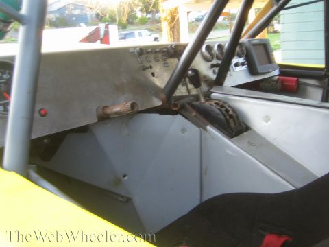 1990 Ford Bronco - Bare cockpit interior of a tube-chassis off-road race vehicle showing the shifter, gauge cluster, and roll-cage tubing.