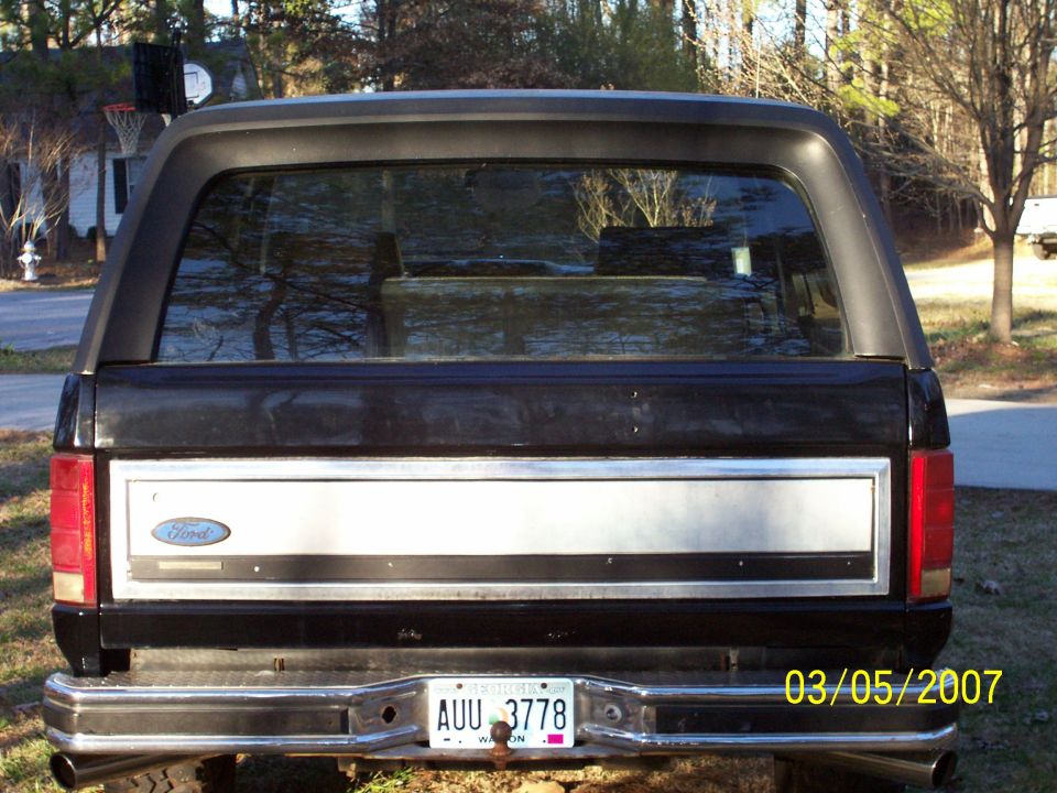 Rear of a black Ford Bronco SUV with Georgia plate AUU 3778, parked on grass.