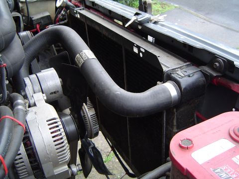 1989 Ford Bronco - Close-up view of the radiator and associated engine components, including hoses and the alternator.