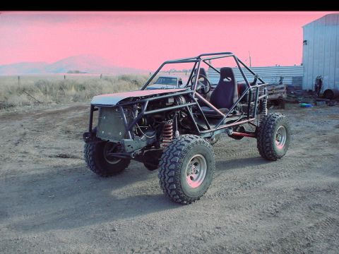 1984 Ford Bronco - A custom-built buggy sits in a dusty yard with buildings and hills in the background.