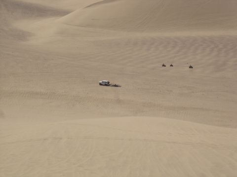 1996 Ford Bronco - Multiple off-road vehicles are seen traversing sand dunes under a clear sky.