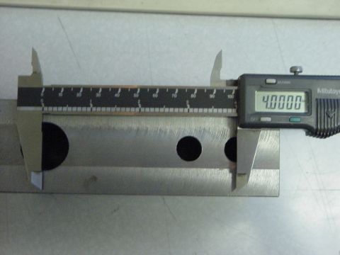 1994 Ford Bronco - A digital caliper measures a metal component, displaying a reading of 4.0000. The part has two circular cutouts.