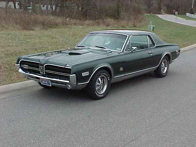 Dark green 1968 Mercury Cougar coupe parked roadside, front three-quarter view