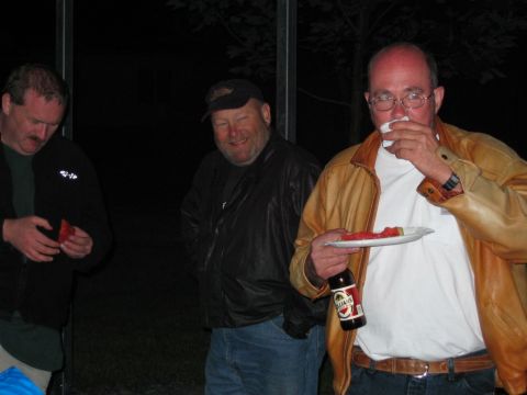 1985 Ford LTD Crown Victoria - Three men enjoy watermelon and beer at an outdoor gathering.