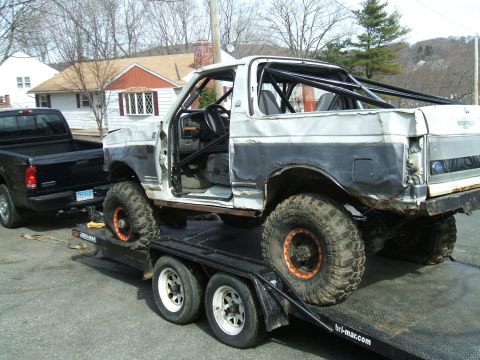 1995 Ford Bronco - This modified 1995 Ford Bronco, equipped with a roll cage and large off-road tires, is being transported on a trailer.