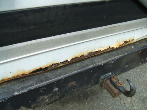 1995 Ford Bronco - Rust is visible on the rear bumper of a vehicle, which has a tow hitch attached.