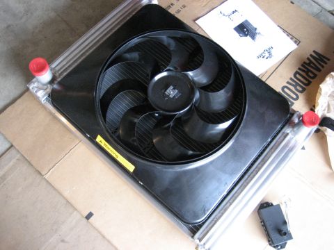 1979 Ford Bronco - Radiator and fan assembly with warning sticker and instructions on cardboard.
