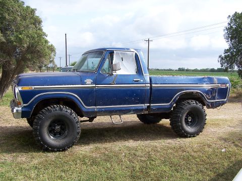 1979 Ford F-150 - This blue 1979 Ford F-150 pickup truck is shown from the side, lifted with large tires.