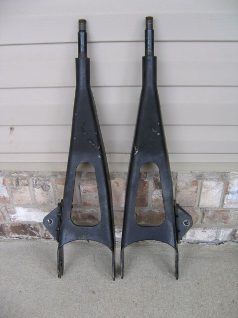 1989 Ford Bronco - Two black control arms are displayed against a textured background, with a website URL visible at the bottom right.