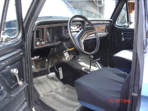 1979 Ford Bronco - The interior of a 1979 Ford Bronco is visible, a black dashboard and seats.
