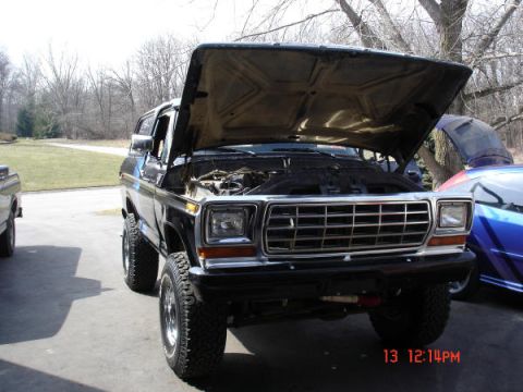 1979 Ford Bronco - 1979 Ford Bronco with hood open, parked outside next to another vehicle.