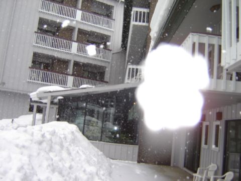 1992 Ford Bronco - A building complex is covered in snow, with a bright light obscuring a portion of the image.