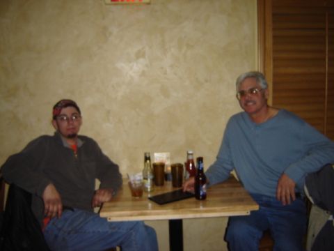 1992 Ford Bronco - Two men are seated at a table in what appears to be a restaurant or bar, with drinks and condiments on the table.