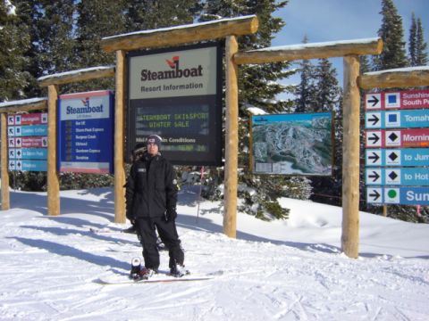 1992 Ford Bronco - A snowboarder poses in front of signs at Steamboat Ski Resort, with a trail map visible.