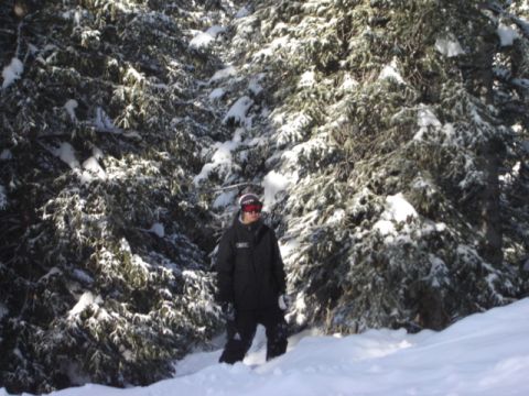 1992 Ford Bronco - A person stands in a snowy forest, surrounded by snow-covered trees.