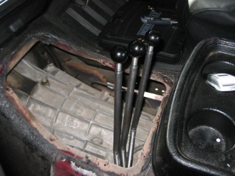 1991 Ford Bronco - Interior view of a vehicle's transmission tunnel with multiple gear shifters and exposed transmission components.