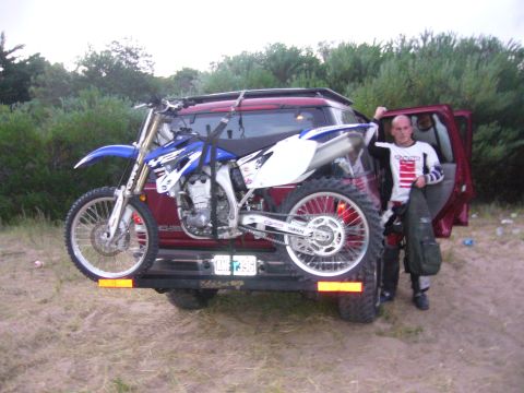 1996 Ford Explorer - Man with dirt bike loaded on SUV rack, ready for off-road adventure.