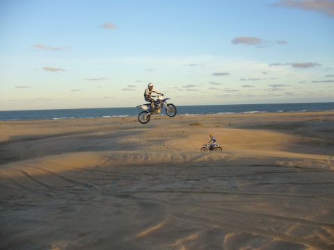 1996 Ford Explorer - Riders catch air on dirt bikes near the coast.