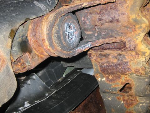 1994 Ford Bronco - Close-up view of severely corroded vehicle undercarriage components.