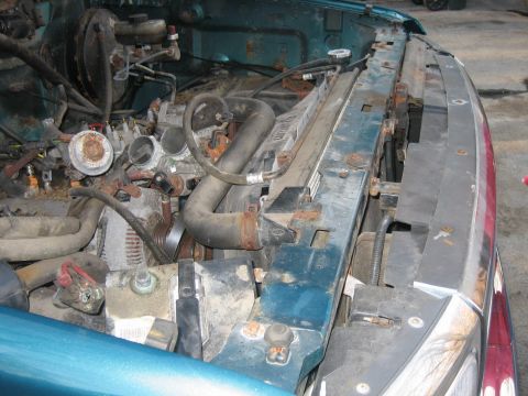 1994 Ford Bronco - Close-up view of a vehicle's engine bay, focusing on the radiator and associated plumbing.