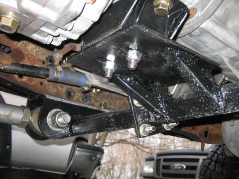 1994 Ford Bronco - Underside view of a vehicle's suspension system, showing a newly installed bracket.