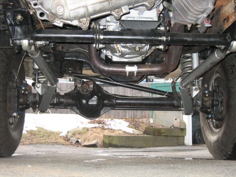 1994 Ford Bronco - The photo shows the front axle, suspension, and exhaust system of a 4x4 vehicle.