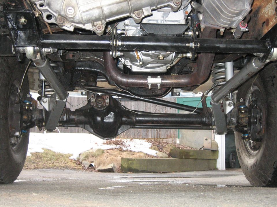 Underside view of a 4x4's front axle, suspension, and drivetrain components
