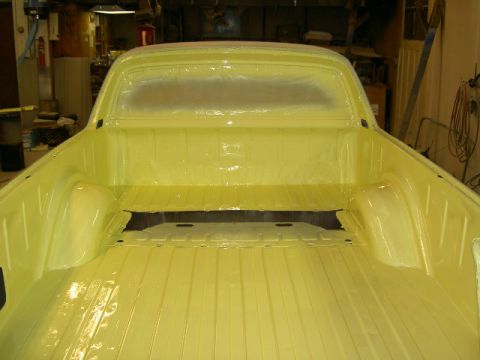 1967 Ford Ranchero - The bed of a 1967 Ford Ranchero shows fresh yellow paint and protective plastic over the rear window.