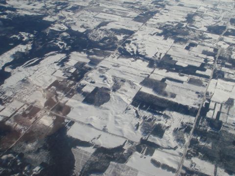 1996 Ford Bronco - Snow blankets rural landscape with fields and roads visible from above.