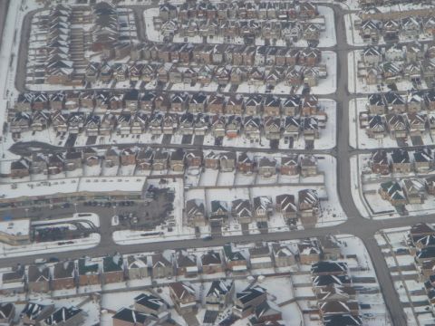 1996 Ford Bronco - An aerial perspective captures a snow-covered suburban neighborhood with rows of houses and streets.
