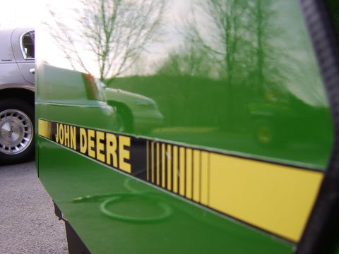 1996 Mercury Grand Marquis - A green John Deere tractor is visible with a reflection of a silver sedan in its glossy finish.