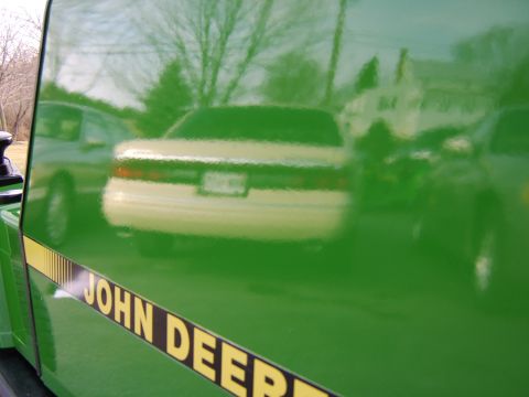 1996 Mercury Grand Marquis - Reflection of a 1996 Mercury Grand Marquis seen on the side of a green vehicle with a John Deere stripe.