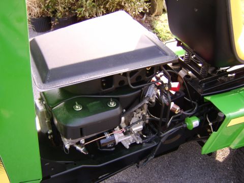 1996 Mercury Grand Marquis - Close-up view of the engine and seat components on a green tractor, showing various mechanical parts and wiring.