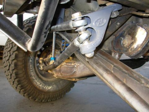 1984 Ford Bronco - Close-up of a vehicle's steering and suspension system, showing modified components and large tires.
