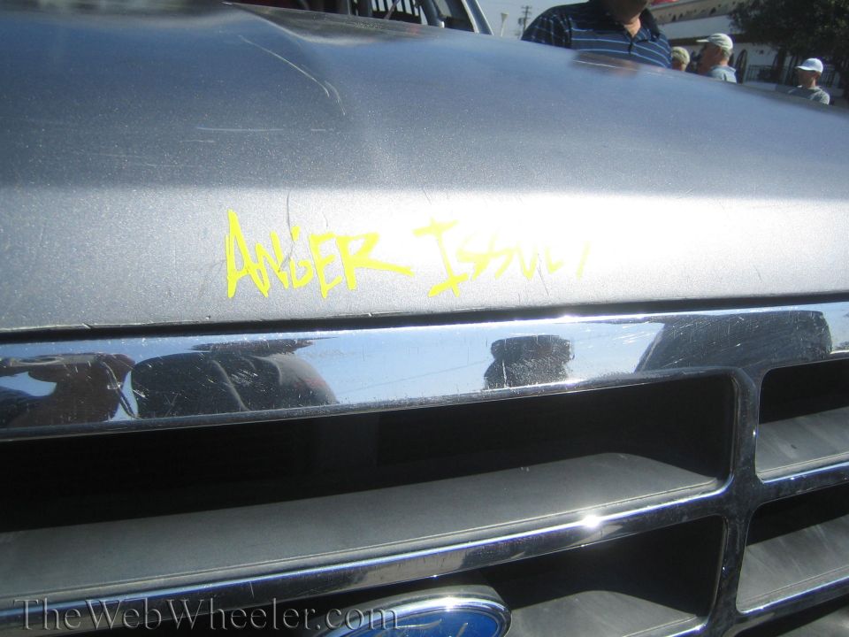 Close-up of a Ford hood and chrome grille hand-lettered Anger Issues in yellow