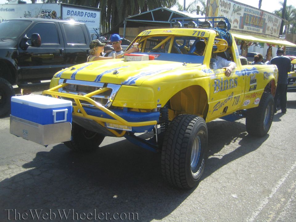 Yellow and blue off-road race truck 719 with cooler strapped to front tube bumper