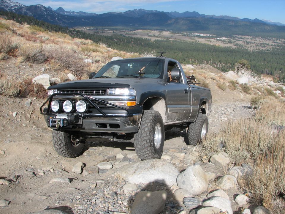 Gray pickup truck with off-road tires and a winch on a rocky trail