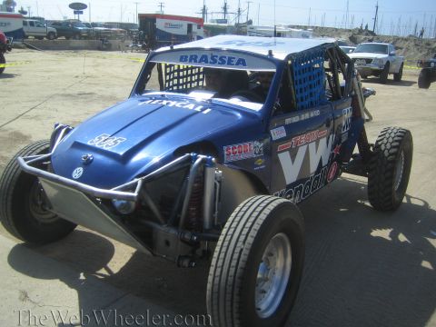 1990 Ford Bronco - blue Volkswagen-powered off-road race buggy marked 505 with Brassea lettering sits on a dirt staging lot.