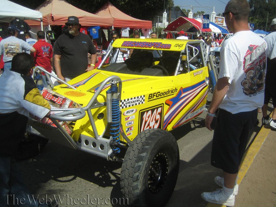 Yellow off-road race buggy No. 1245 with star graphics and crowd at event